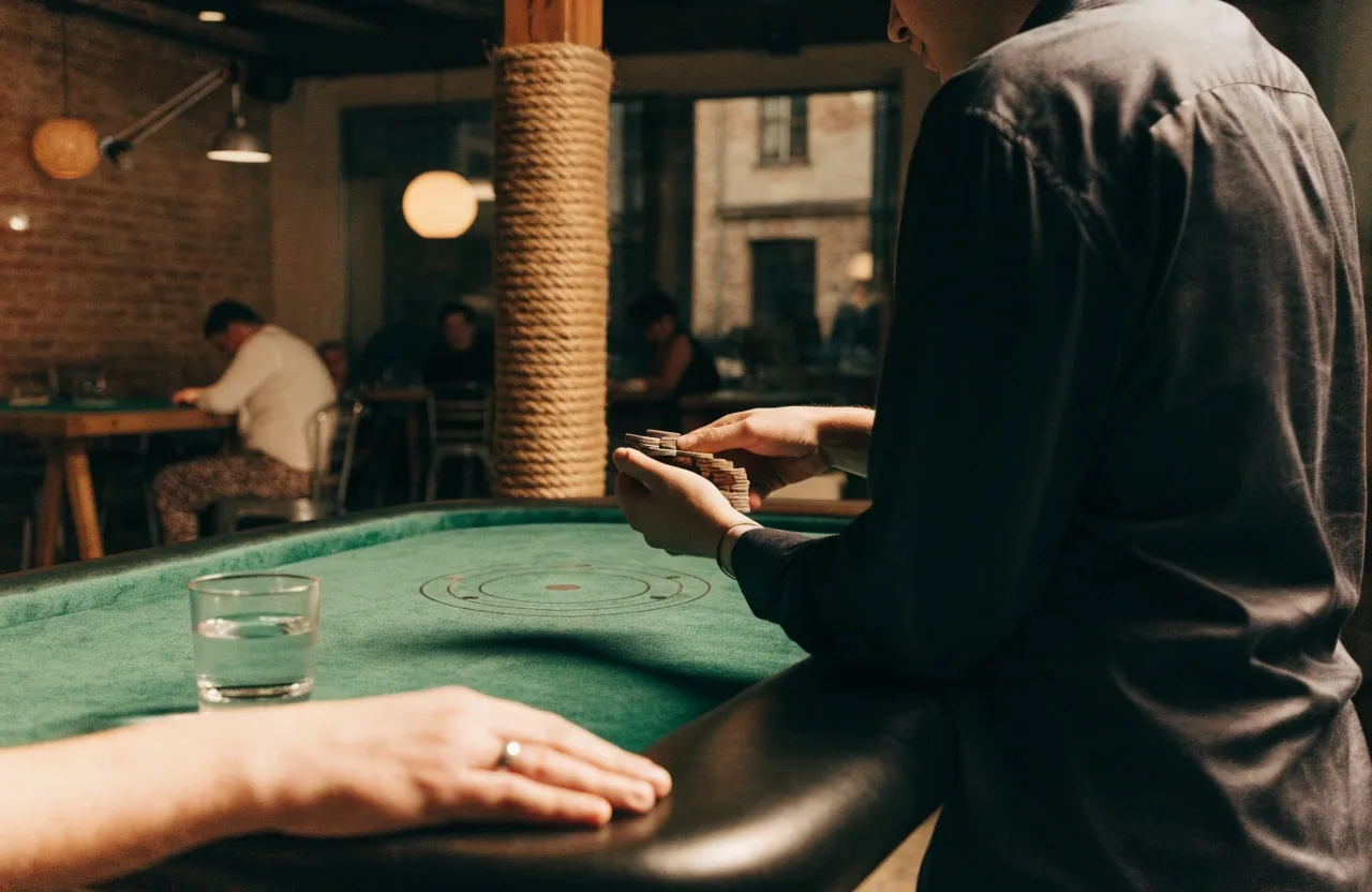 Dealer počítá žetony na stole před začátkem turnaje